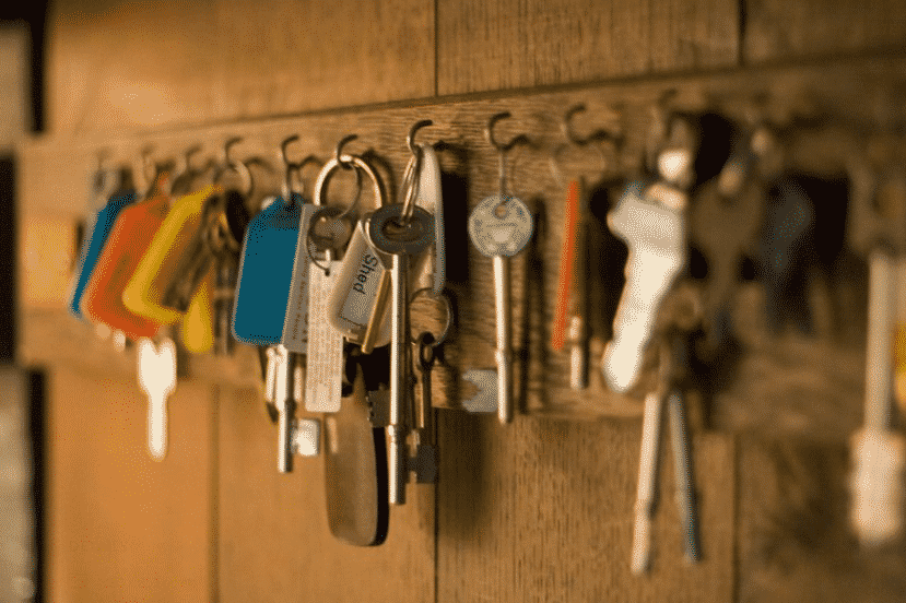 chaves de vários tipos diferentes penduradas em ganchos presos em uma parede